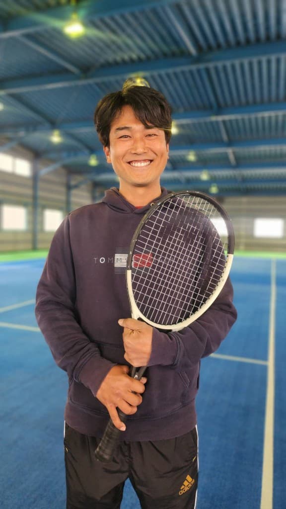 インドアコートでラケットを持つヘッドコーチ 勝野颯太